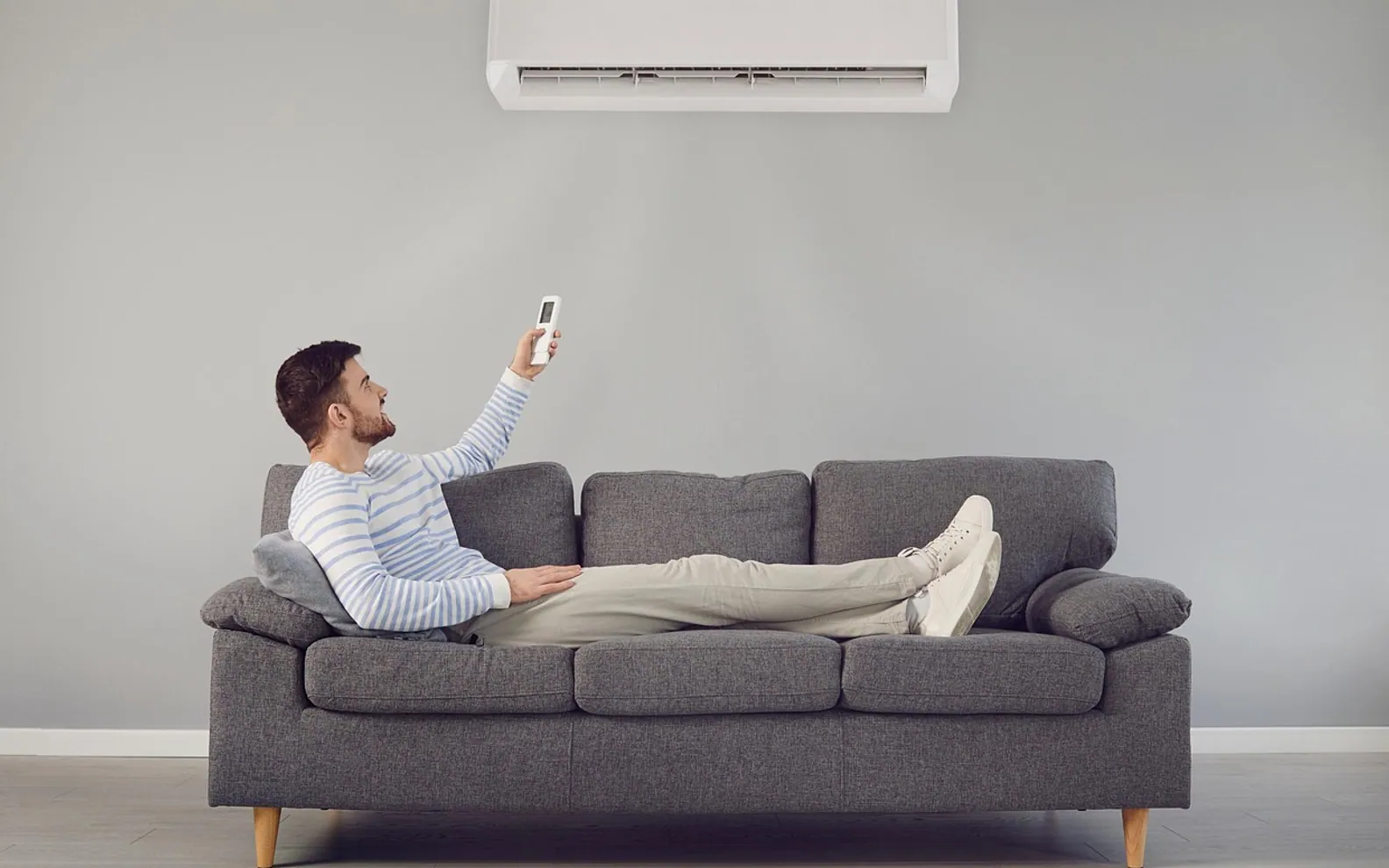Air conditioner, man and sofa
